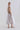 Side view of the bi-color sleeveless dress, showing its architectural contrast and softly adjustable waist silhouette