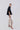 Side view of Psophía embroidered stretch piqué pants highlighting fluid drape and structured contemporary fit.