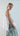 Side view of the sleeveless top showing relaxed oversized fit and geometric side points