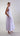 Side view of mercerized cotton midi dress highlighting the cascading rosette detail and fluid sculptural movement.