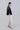 Side view of soft volume relaxed pants showing fluid drape, elastic waistband and tapered hem
