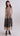 Sleeveless V-neck dress with A-line midi skirt and floral appliqué, combining artisanal detail and fluid movement