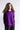 Structured long-sleeve top shown on a plain background, featuring a classic round neckline and a folded origami-inspired side detail that adds a subtle architectural shape.